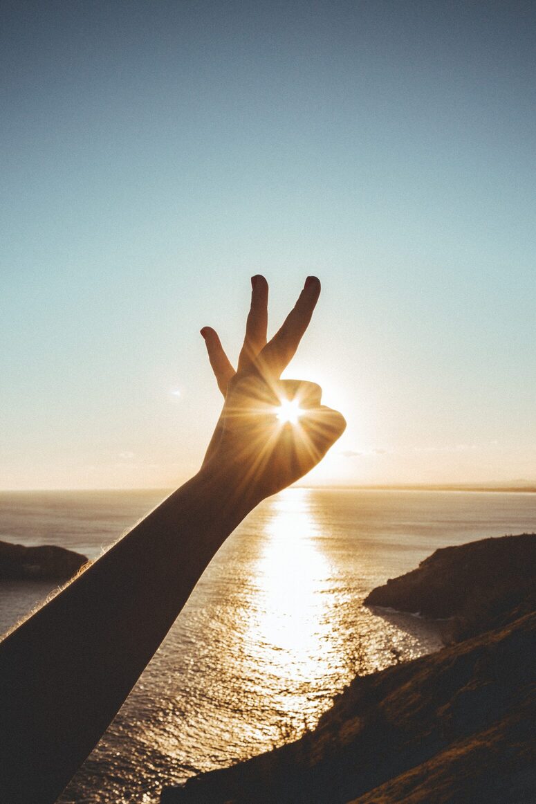 Daumen und Zeigefinger zeigen Richtung Sonne – symbolisch für gezielte Vitamin D Therapie in München